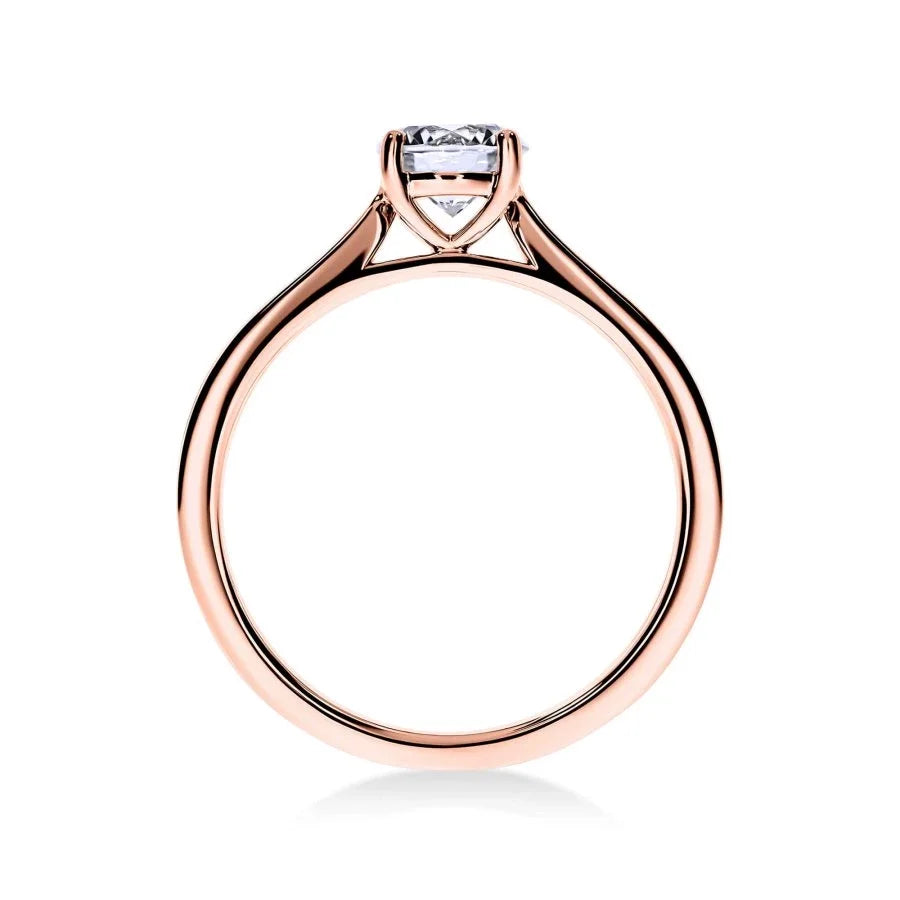 Gros plan du diamant rond sur la bague Élégance en or rose, mettant en valeur la féminité du design.