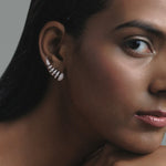 Gros plan sur les diamants taille rond des boucles d’oreilles en or blanc, révélant l'éclat moderne et le design unique.