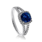 Gros plan du saphir bleu sur la bague Saphir Impérial en or blanc, mettant en valeur la taille coussin et le pavage de diamants.