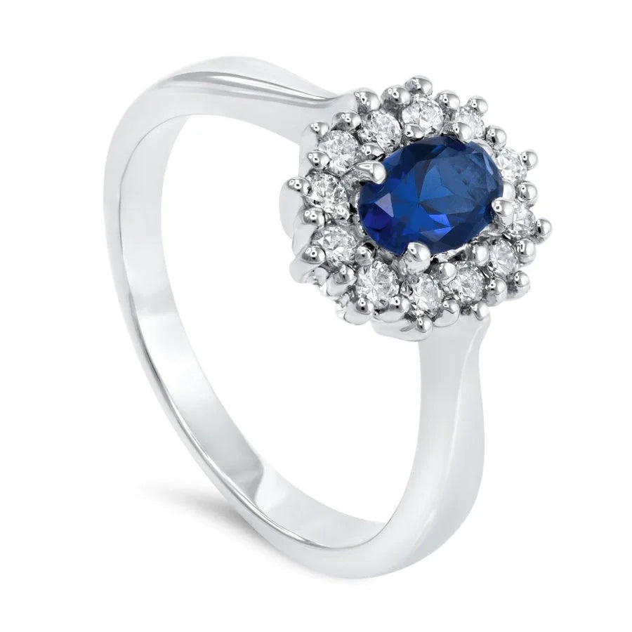 Gros plan du saphir bleu sur la bague Saphir Royal en or blanc, mettant en valeur la monture en pavage de diamants scintillants.