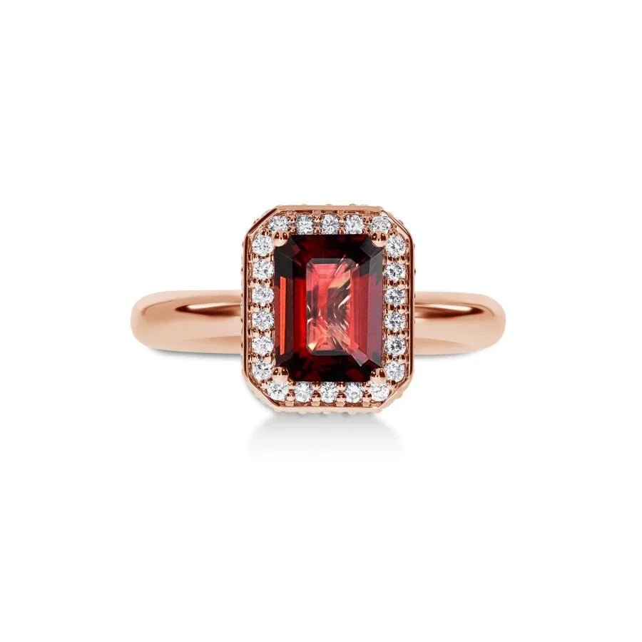 Gros plan du grenat sur la bague Symbole Rosso en or rose, mettant en valeur le halo de diamants.